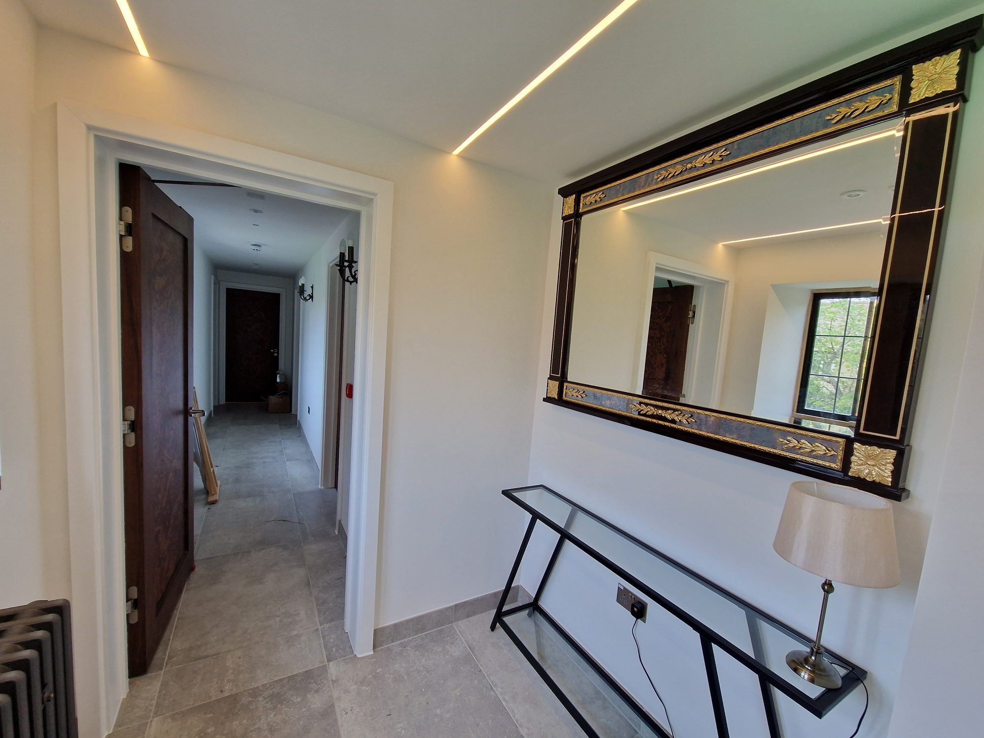 Refurbished hallway with a feature mirror and recessed lighting