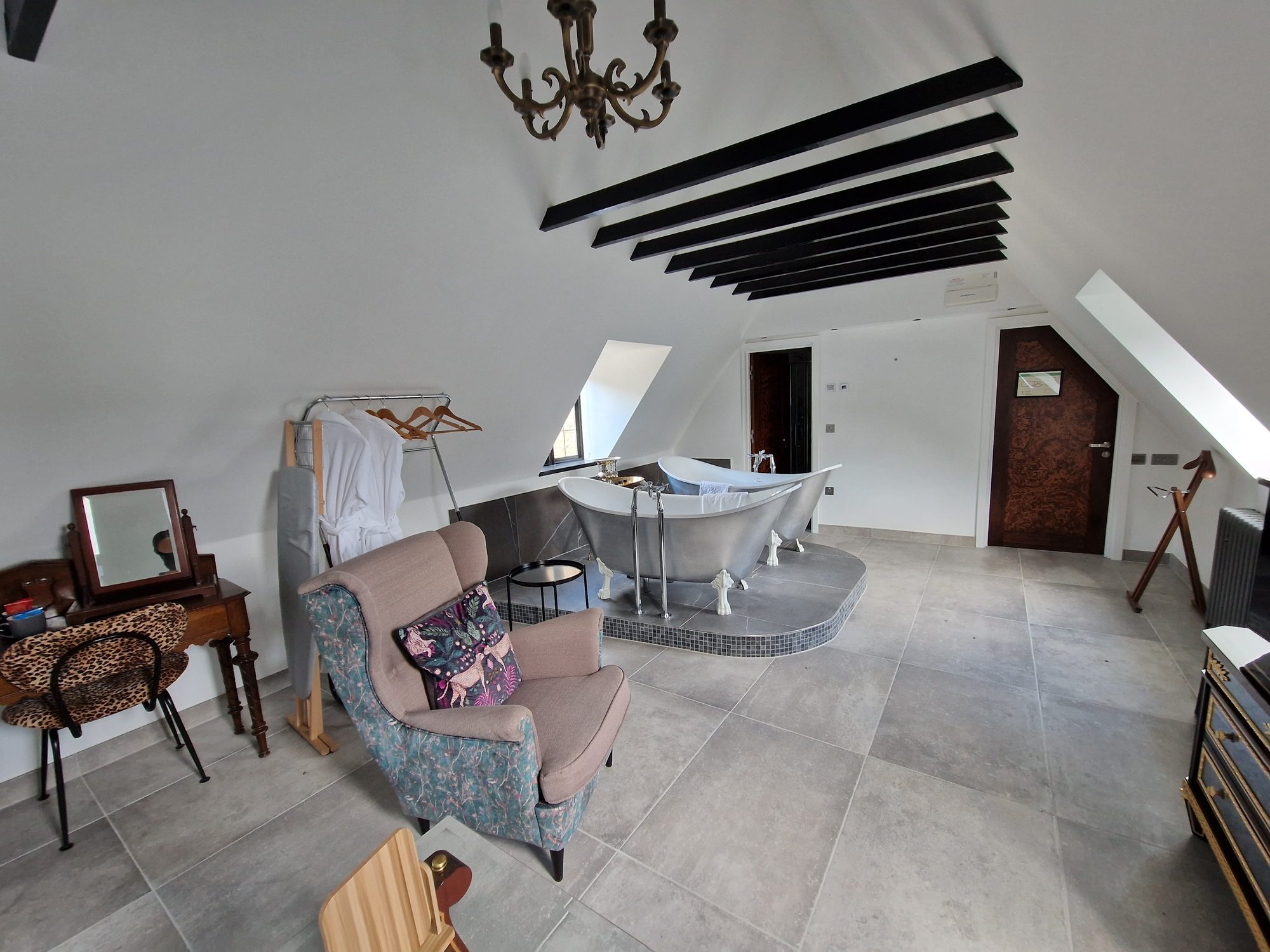 Roof suite with a freestanding bath and exposed beams