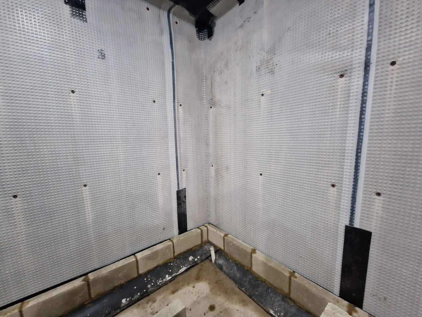 Basement walls lined with a waterproofing membrane