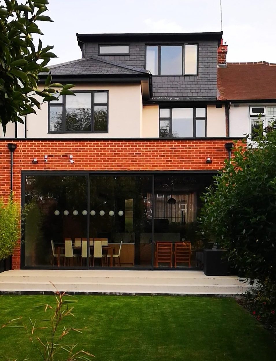 House with a glazed rear extension and a loft dormer