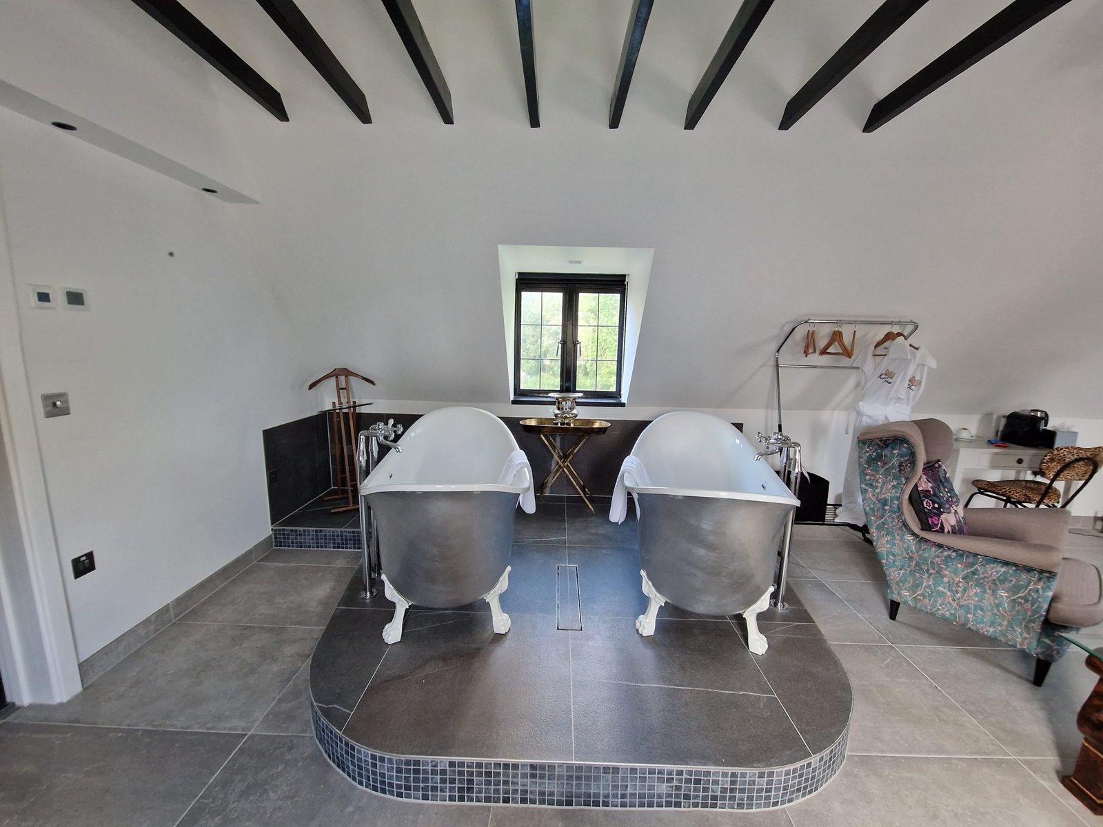 Two freestanding baths on a tiled plinth